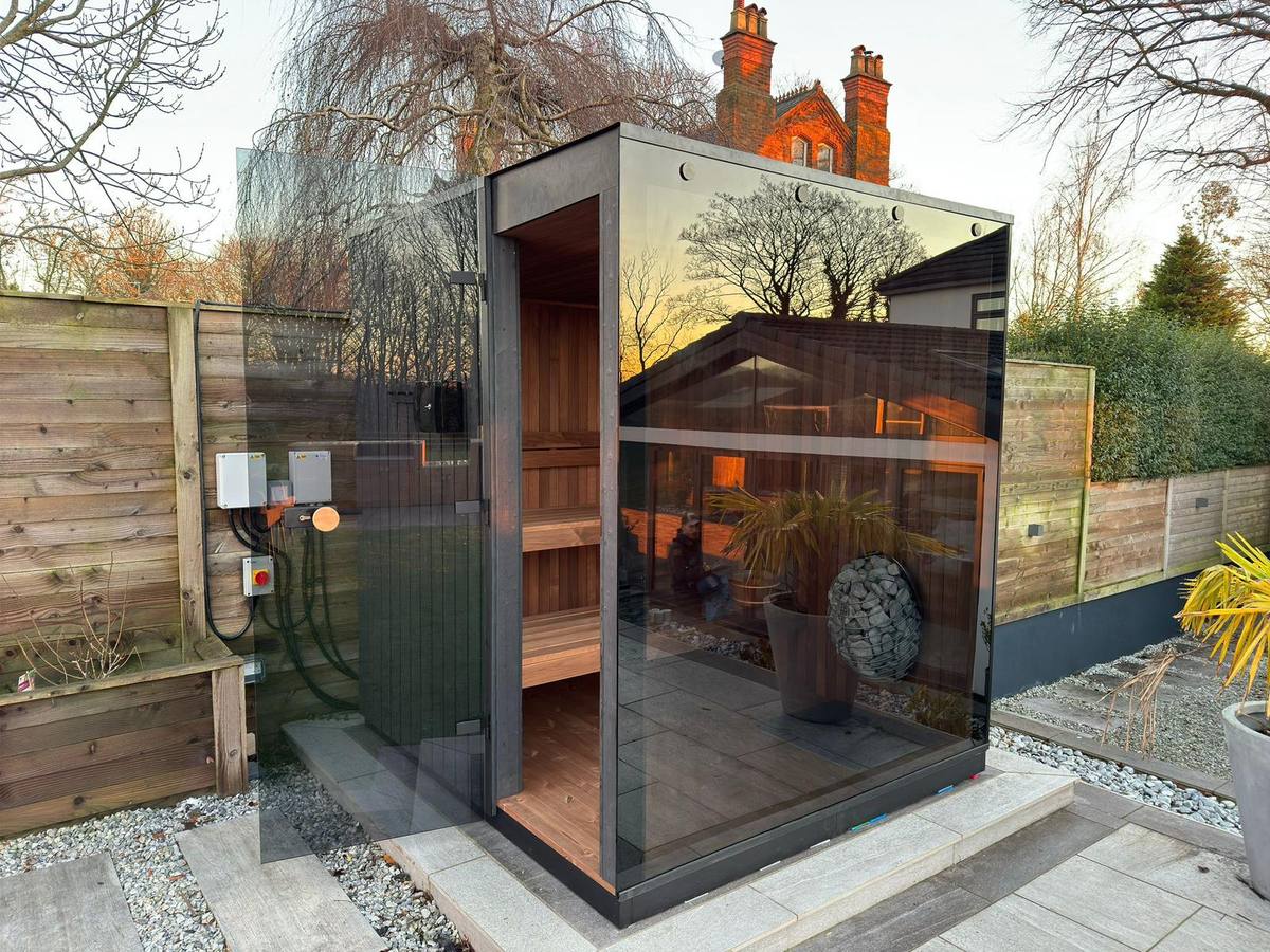 Installed Wood Architects panoramic cube sauna showing the door, glazing and service side