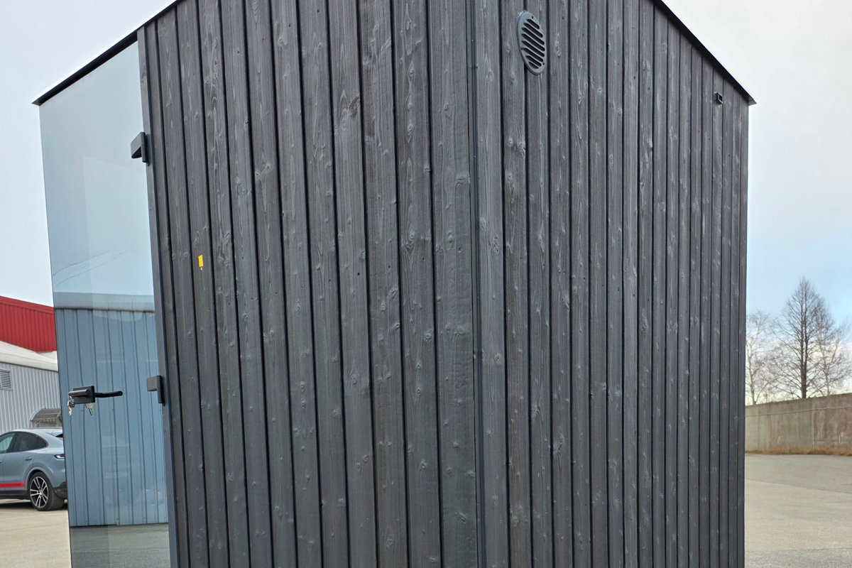 Real dark timber cladding on a modern cube sauna, shown without inferring its treatment process from colour.