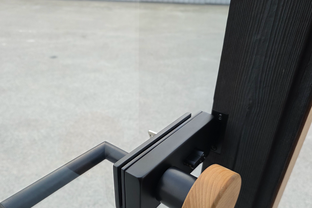 Real door hardware and timber interface on a modern cube sauna.