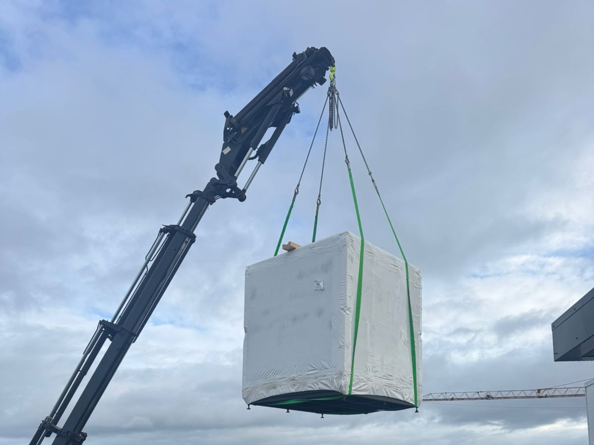 Photographed wrapped prefabricated module during a lift and unload operation.